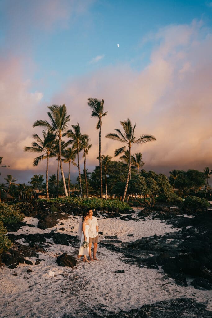 couple watching sunset after elopement at Kikaua Point Park in Kailua Kona